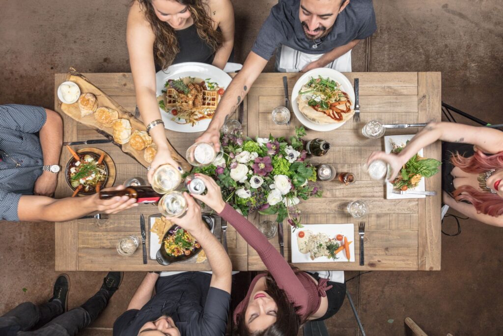 A group enjoying a special celebration meal at Hash House A Go Go Mohegan, featuring hearty comfort food, drinks, and a festive dining atmosphere.